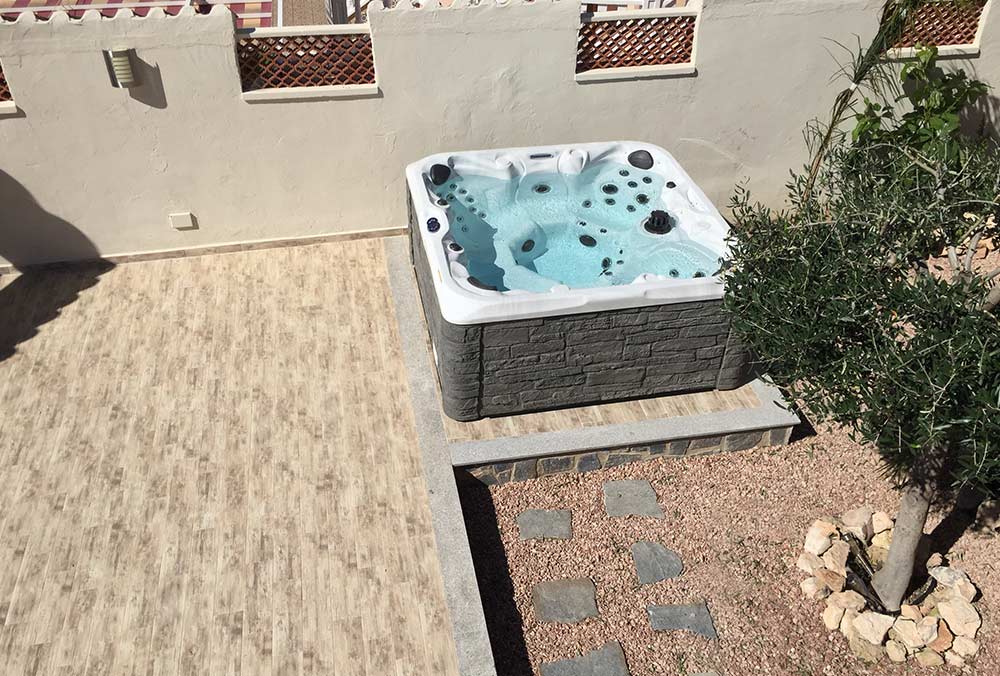 Hot tub with stone skirt on patio