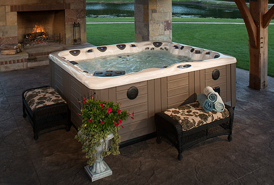 Hot tub installed on covered patio with fireplace