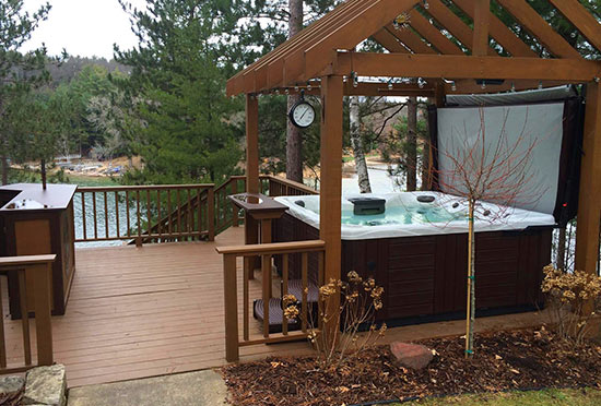 Hot tub on deck with pergola and lake view