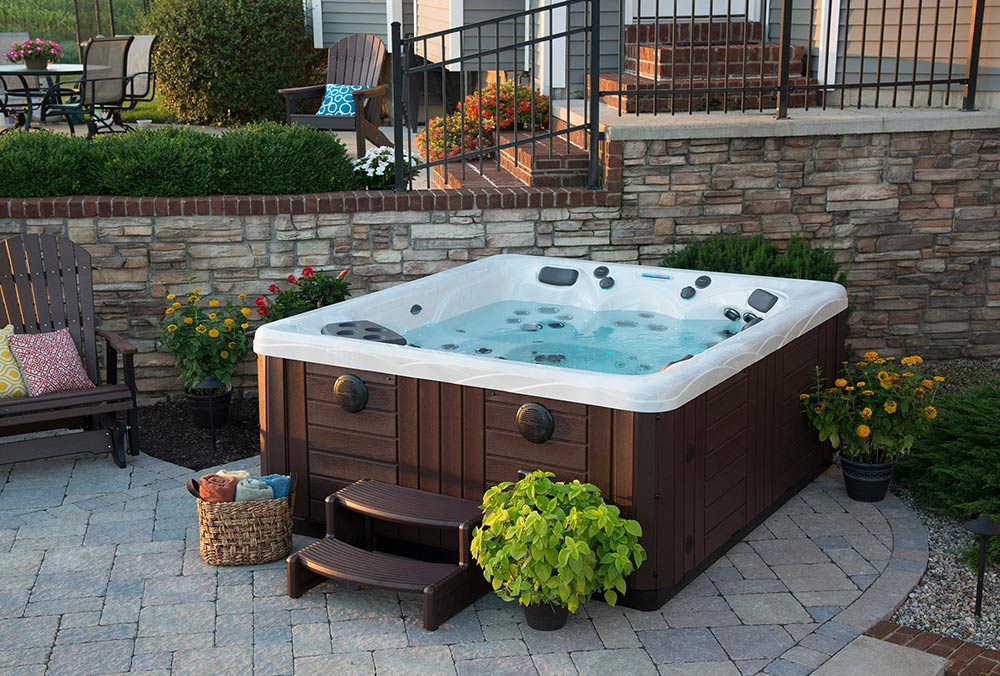 Hot tub installed on paver patio with landscaping